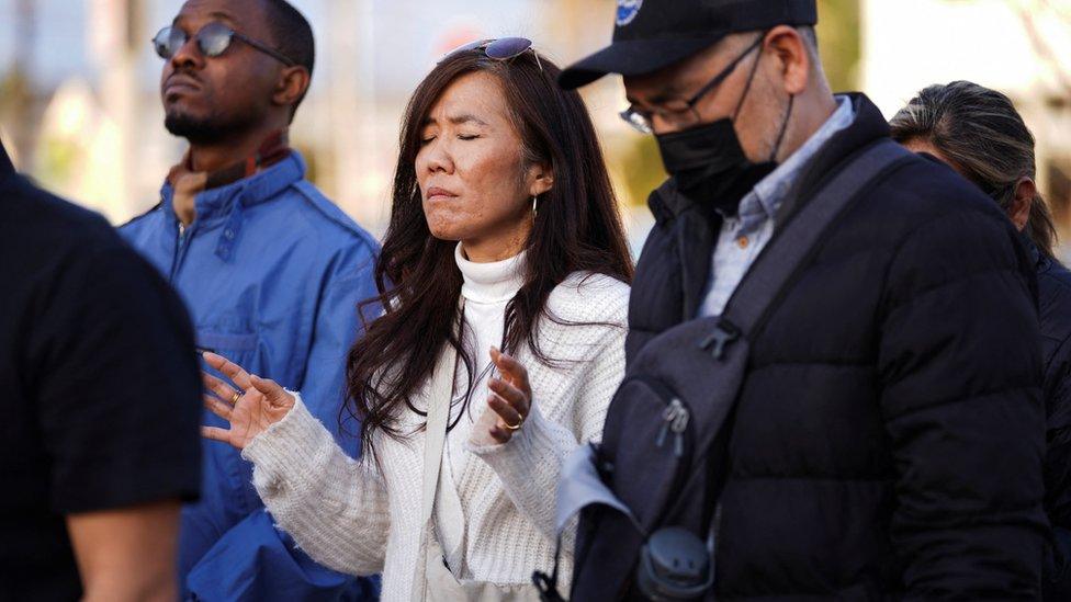 A woman holds her arms in prayer