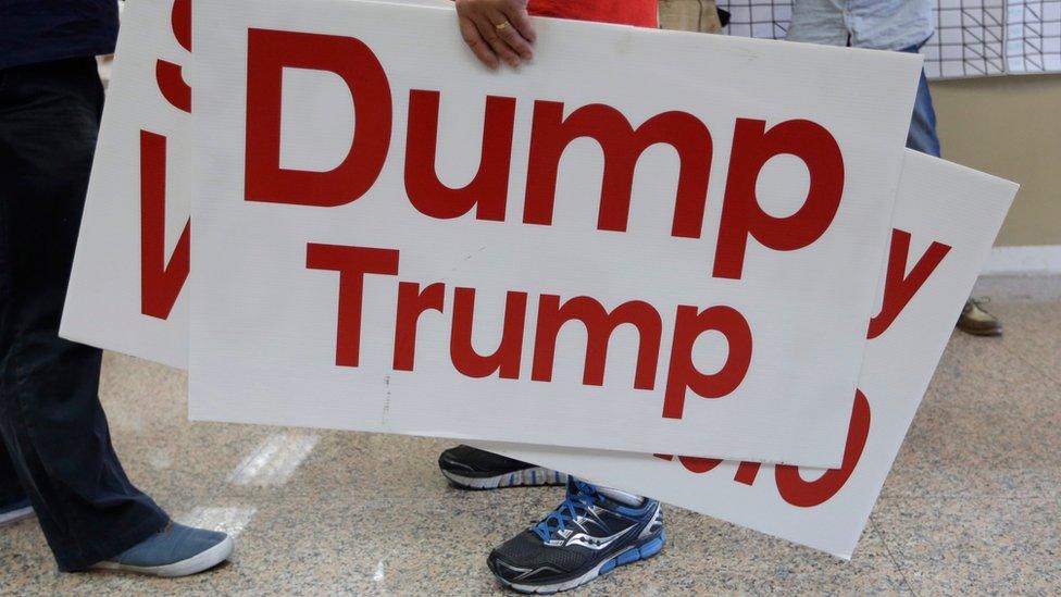 A supporter of Republican presidential candidate Marco Rubio carries a sign reading "Dump Trump", in reference to candidate Donald Trump