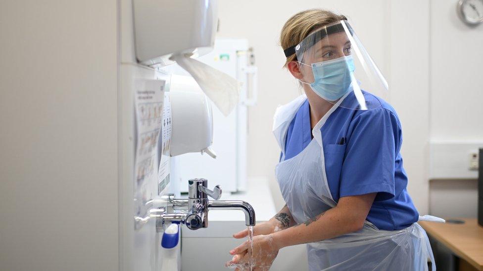 Nursing wearing PPE washing hands