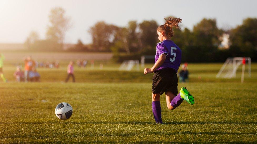 Girl playing football.