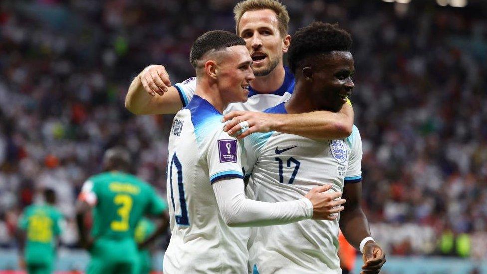 England's Bukayo Saka celebrates scoring his goal in the match against Senegal at the Qatar World Cup with team-mates Harry Kane and Phil Foden on 4 December 29022