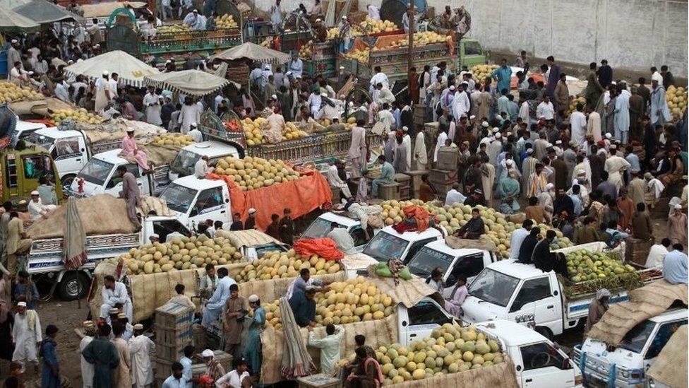 Fruit sellers sell fruit at a market in Karachi, Pakistan, 26 May 2017.