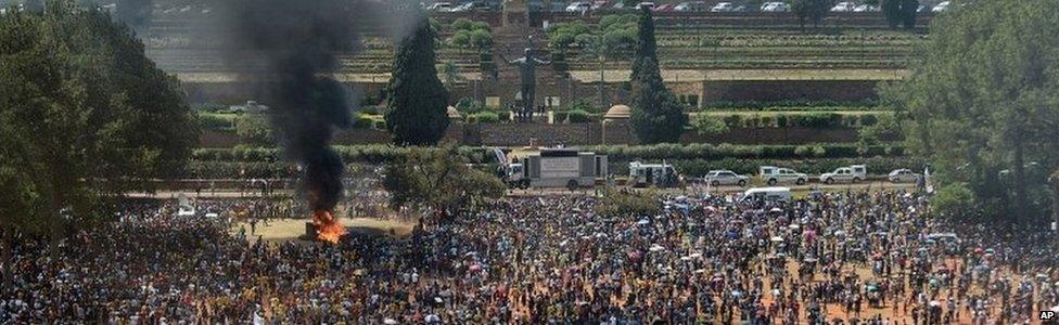 Students burn portable toilets during their protest against university tuition hikes outside the union building, background) in Pretoria, South Africa,