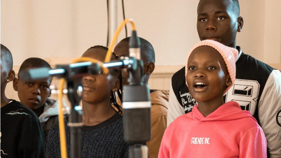 A choir of Zulu children singing and dancing