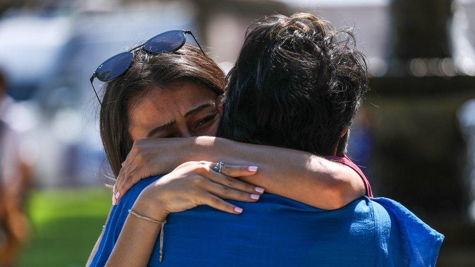 Mourners visit a memorial for a victims