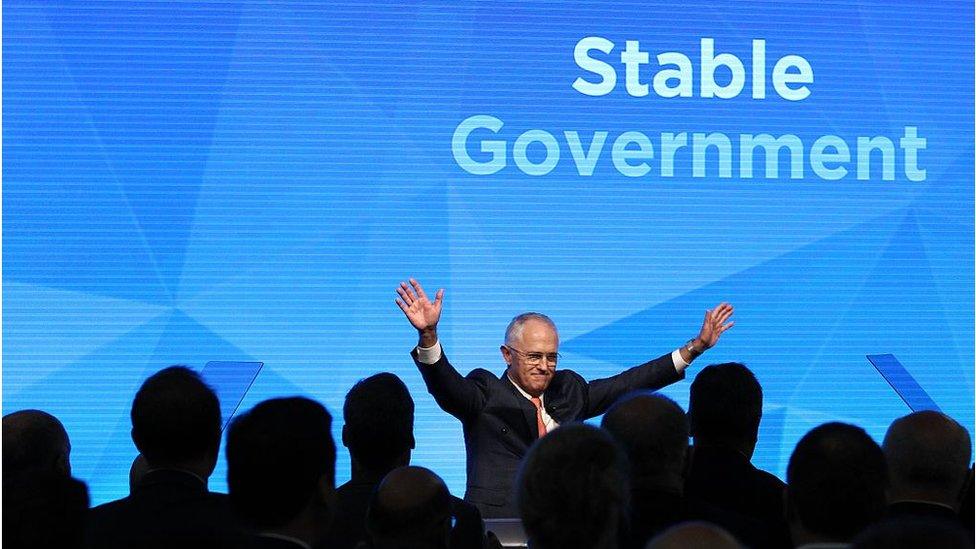 Prime Minister Malcolm Turnbull stands beneath a screen that reads "stable government"