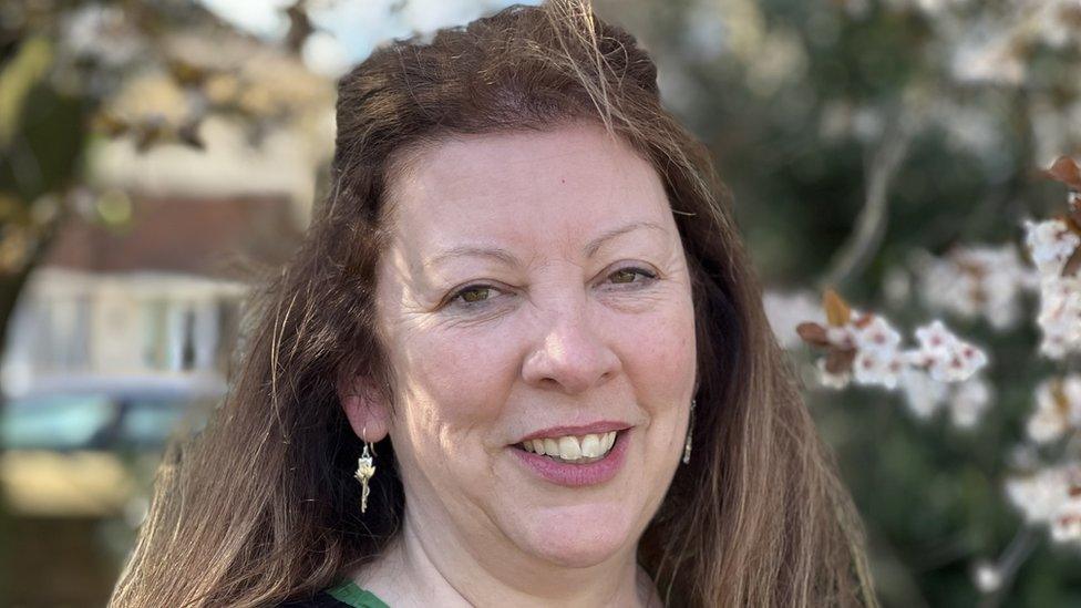 Care worker Tracey Davidson photographed outside in front of a house and a cherry tree