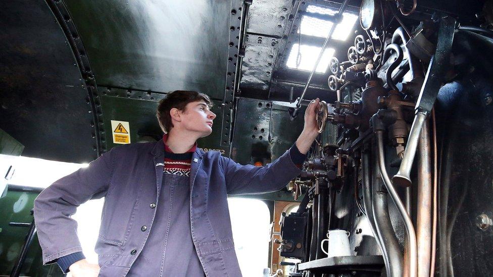 An engineer looks at gauges inside the engine of The Flying Scotsman