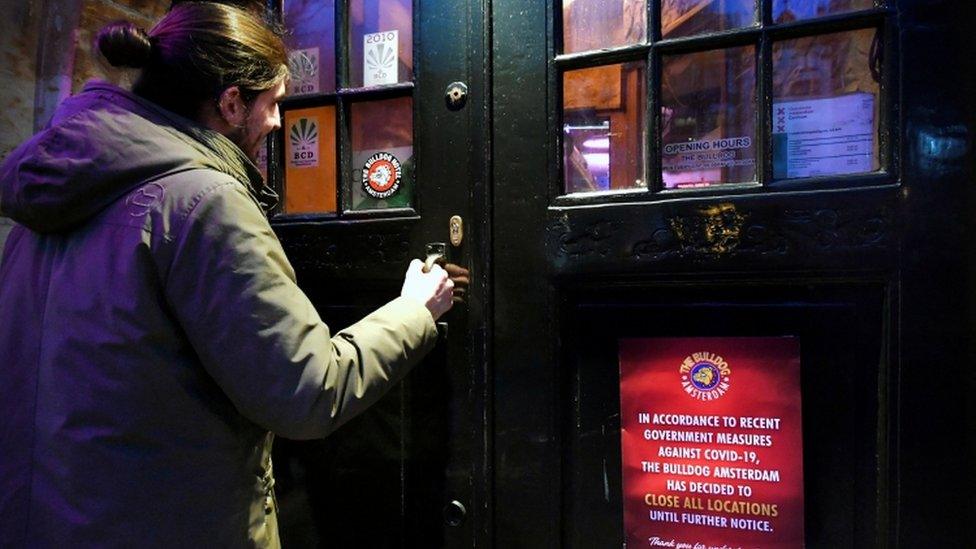 A man walks into a coffeeshop in Amsterdam's Red Light district