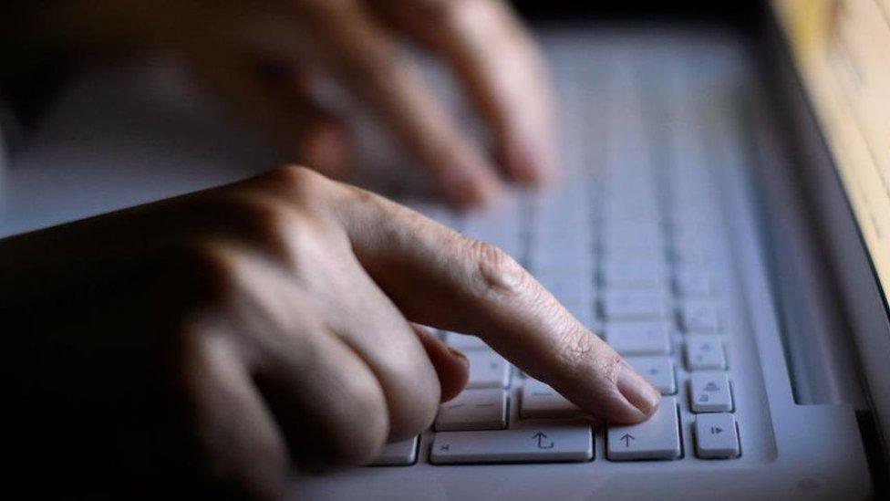 Person using a laptop computer keyboard