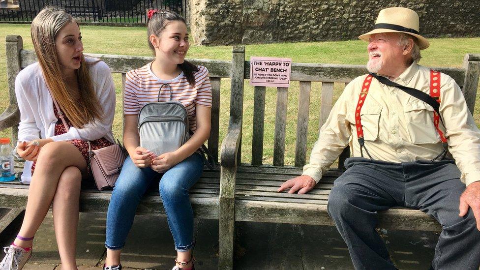 two young women and man on bench