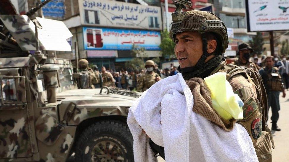 An Afghan soldier shifts a baby at the scene of an attack at MSF (Doctors without Borders) hospital, in Kabul, Afghanistan, 12 May 2020.