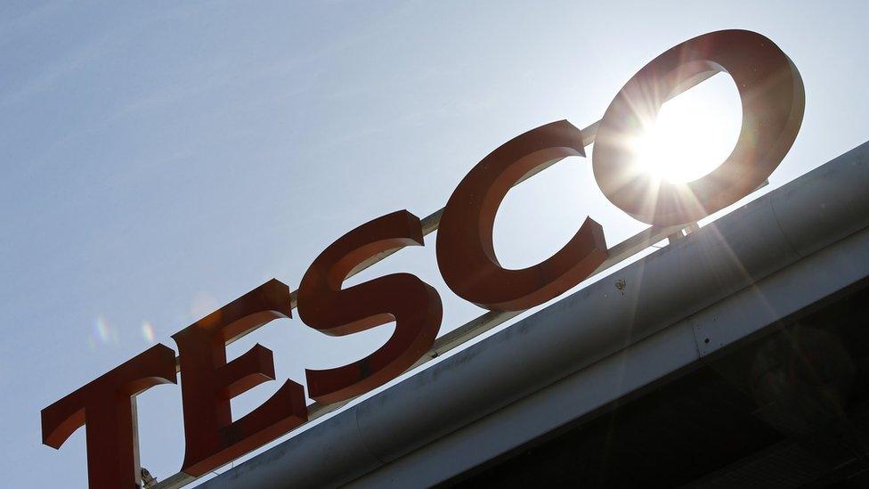 Tesco sign with sun behind it