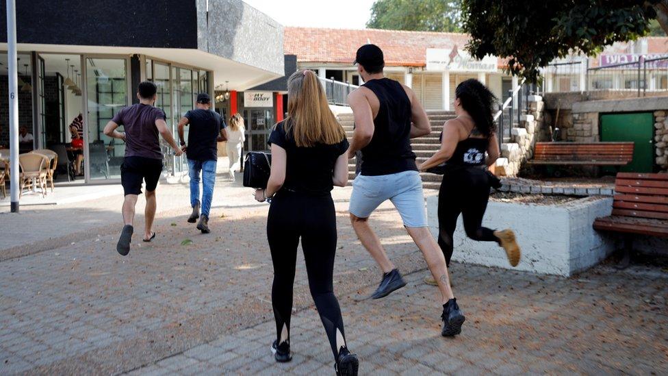 People run to take shelter when an air raid siren sounds in Ashkelon, southern Israel (13 November 2019)