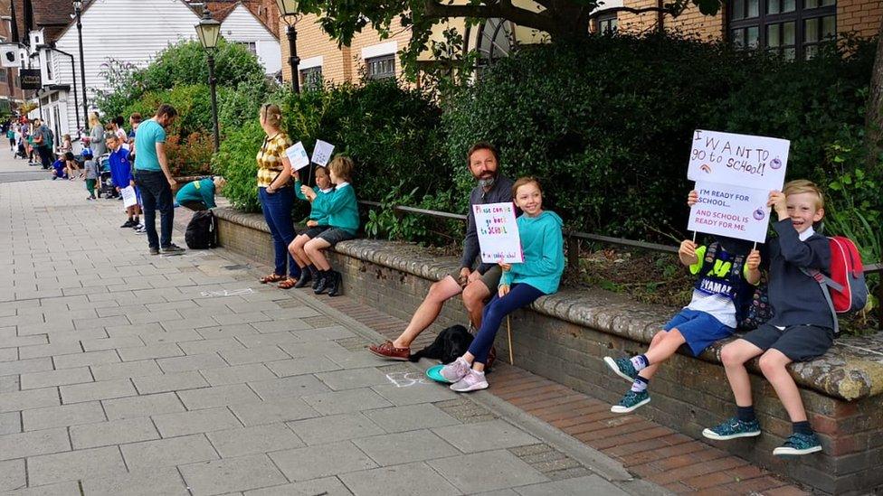 Pupils and parents queued up around the council's offices in a socially distanced protest