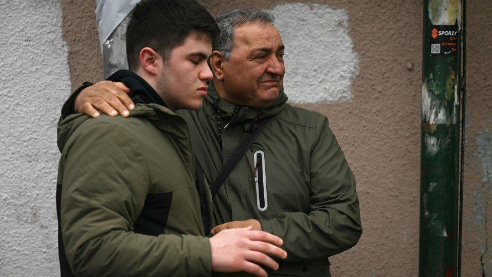 A relative of one of the injured worshippers grieves in front of Santa Maria church, as Turkish anti riot police officers block the street after the attack