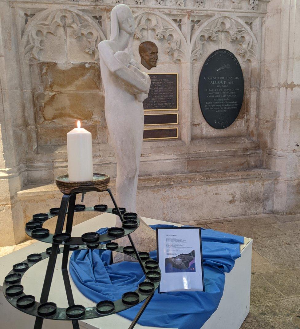 A statue and candles were people can pray for the people of Ukraine and Russia at Peterborough Cathedral