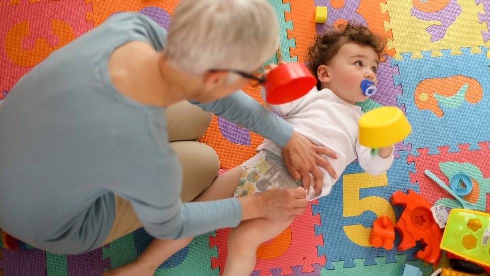 Childminder changes nappy