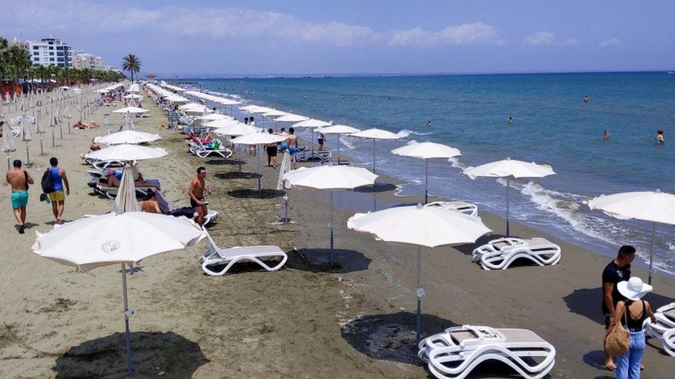 People walking along a beach in Cyprus