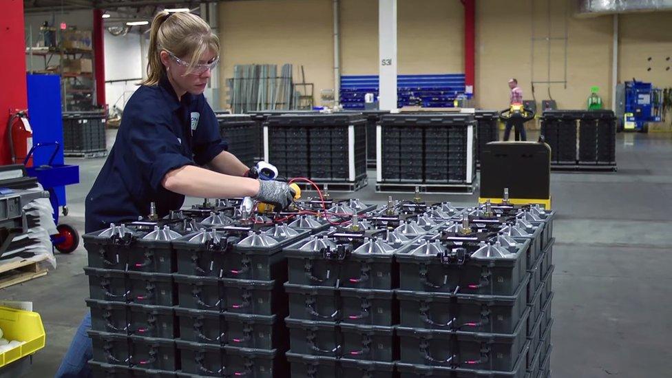 Woman working on stack of Aquion batteries