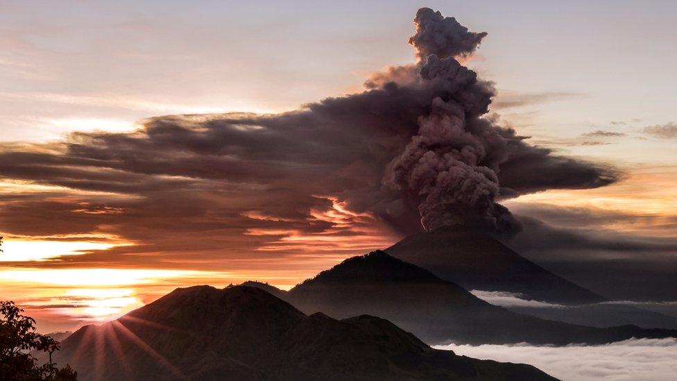 Mount Agung volcano is seen spewing smoke and ash