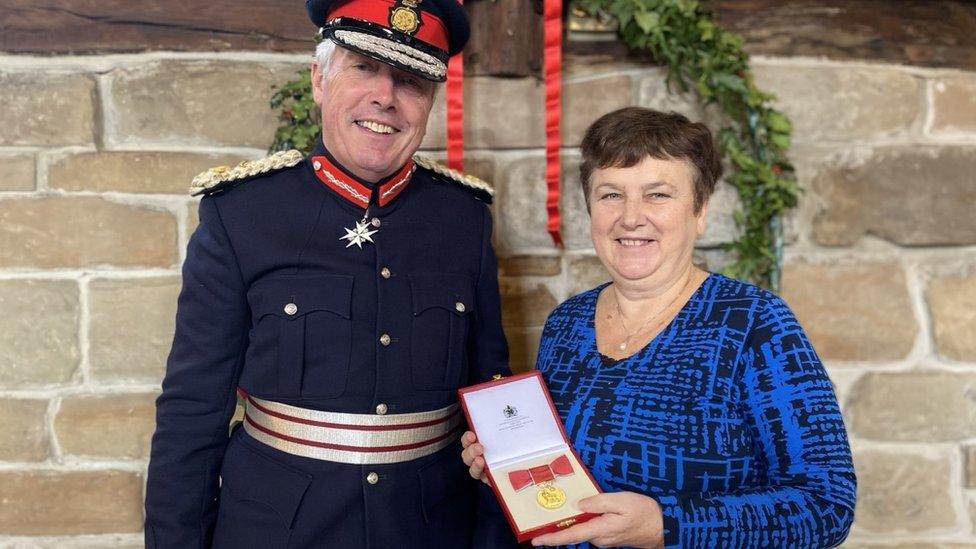 Carole Zambonini receiving her MBE from the Lord Lieutenant of Warwickshire Tim Cox