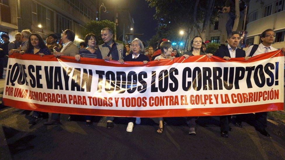 People holding sign against corruption, protest against Congress after it passed a motion to remove President Pedro Pablo Kuczynski from office in Lima, Peru, December 20, 2017