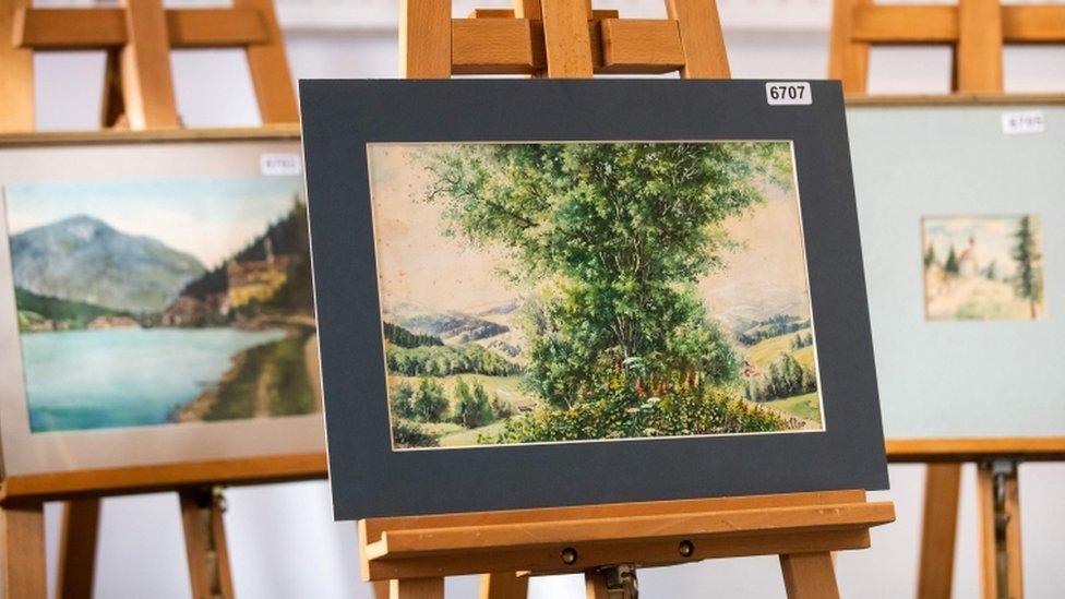 Watercolour paintings are displayed on an easel