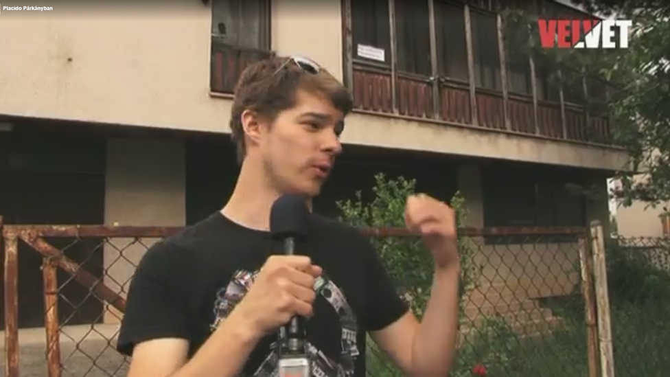 A reporter pointing at the house where the music was played