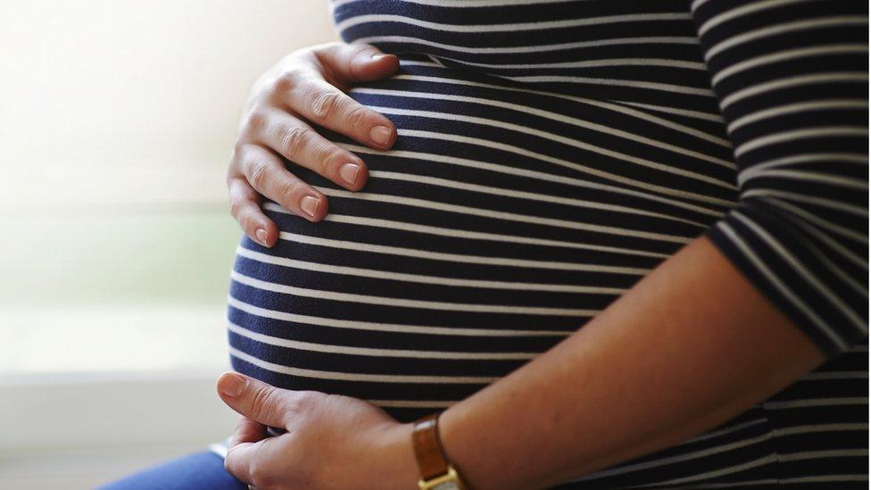 Pregnant woman holding her bump