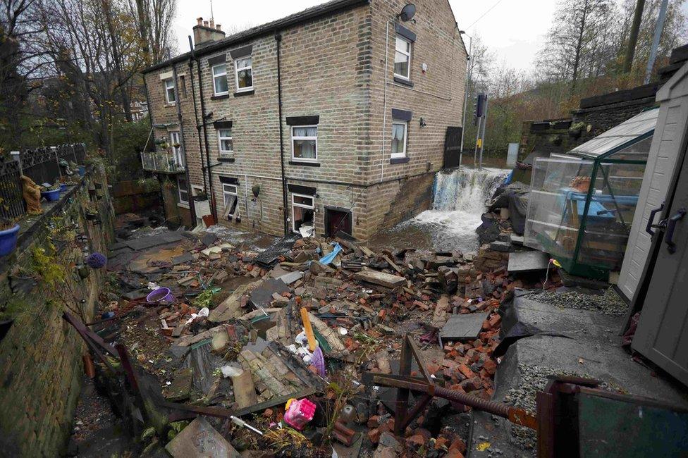 Flood water flows past terraced houses in Stalybridge