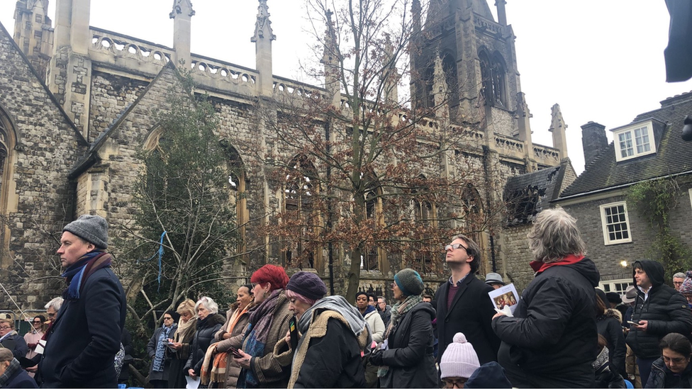 Congregation gather outside St Mark's Church, which was partially destroyed in a fire.