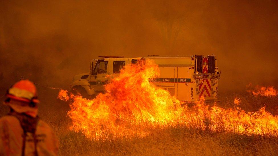 A fire vehicle is surrounded by flames as the Pawnee fire jumps across highway 20 near Clearlake Oaks, California on 1 July 2018