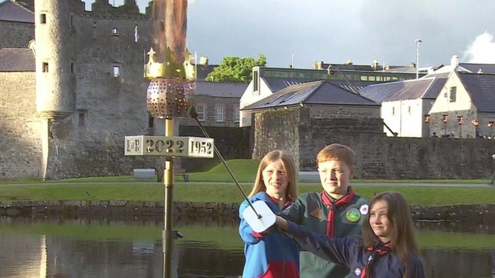 Local scouts Hayley Woods, Erin McCullough-Daley and Evan Clarke light beacon at Enniskillen Castle