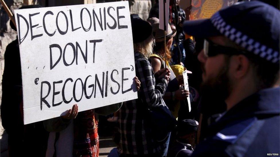 Police stand in front of protesters as they chant slogans and hold placards outside the venue for a meeting between Australia's Prime Minister Tony Abbott and 40 of the nation's most influential indigenous representatives in Sydney, Australia, July 6, 2015.