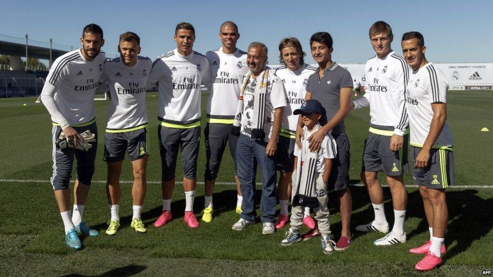 Osama Abdul Mohsen and his sons Mohammad and Zaid pose with Real Madrid players, goalkeeper Kiko Casilla, Russian midfielder Denis Cheryshev, Portuguese forward Cristiano Ronaldo, Portuguese defender Pepe, Croatian midfielder Luka Modric, German midfielder Toni Kroos and midfielder Lucas during a training session at Valdebebas training ground