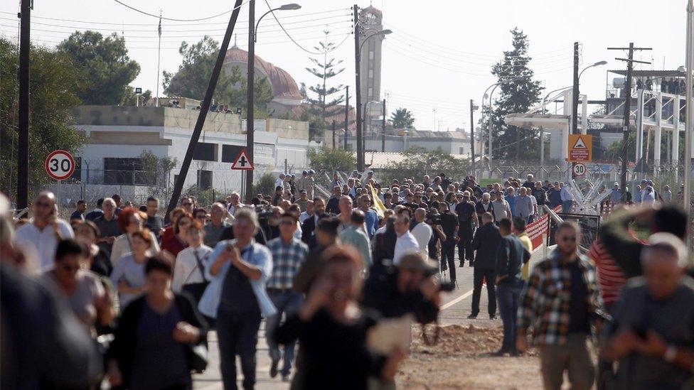 People cross at a newly opened checkpoint linking the Greek and Turkish Cypriot communities in Dherinia, Cyprus November 12, 2018.