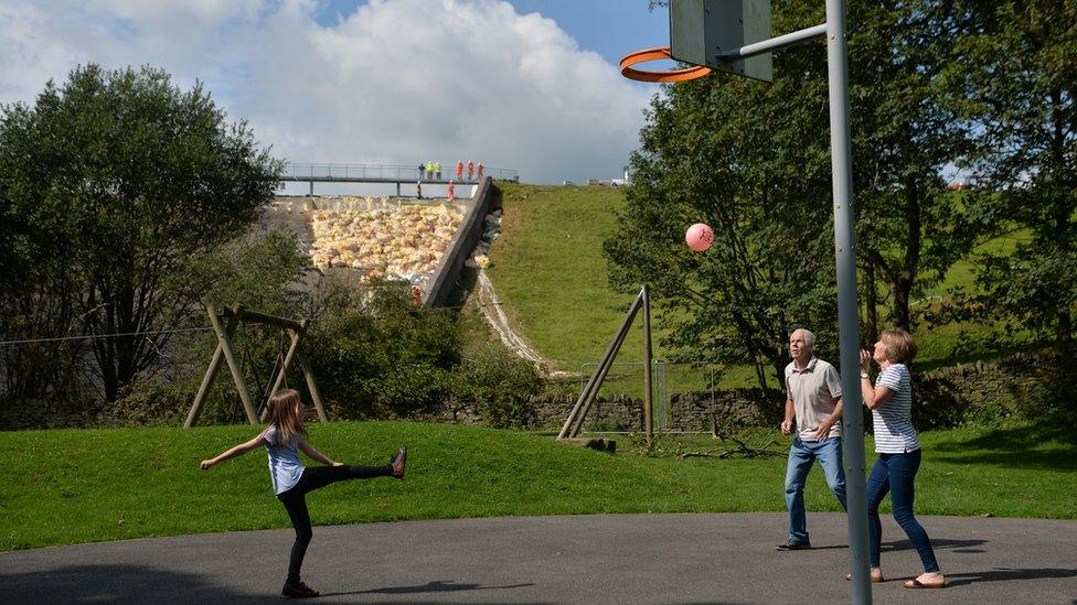 Family plays in shadow of dam