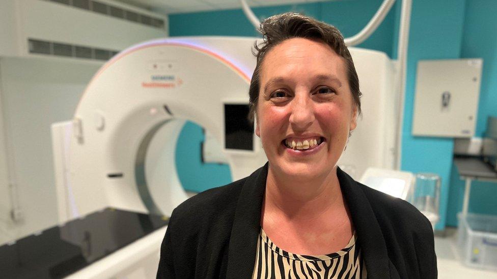 Lady smiling in front of hospital machine