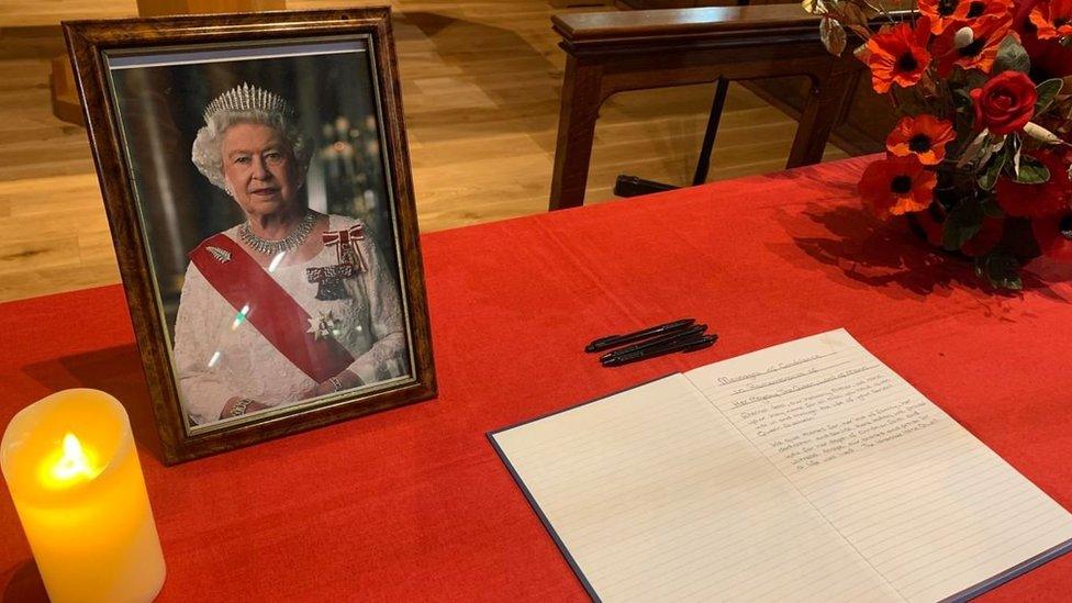 A book of condolence next to a photo of Queen Elizabeth II