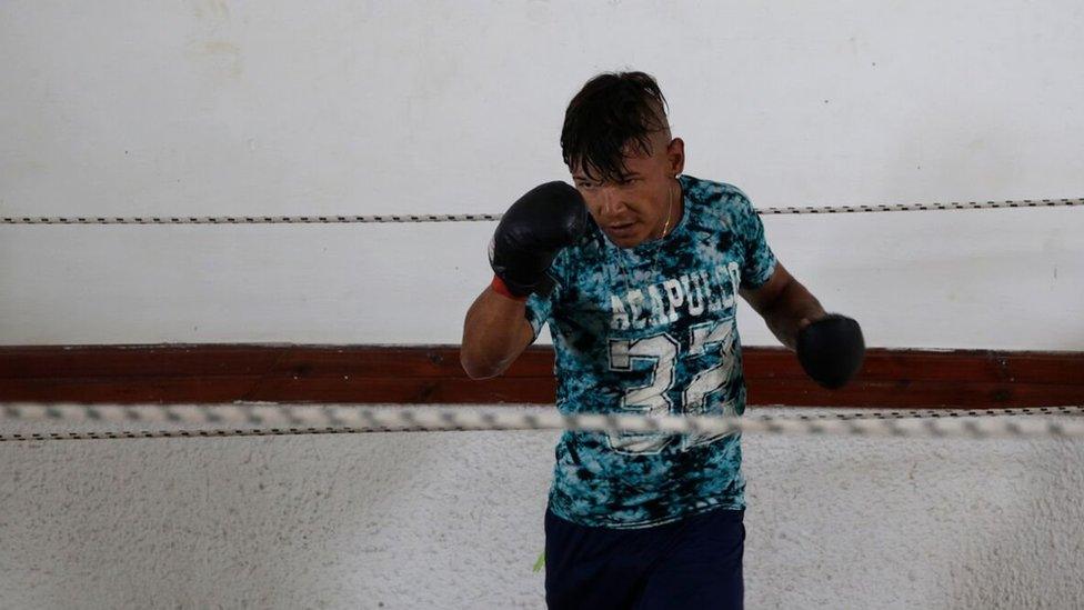 An inmate with boxing gloves practices in a ring