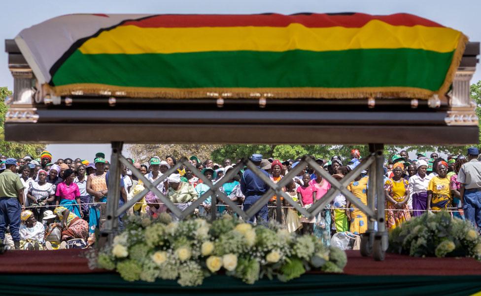 Villagers look at the coffin of late former Zimbabwean president Robert Mugabe lying in state at Murombedzi Growth Point, about 107 km northwest of Harare, Zimbabwe, on September 16, 2019, as people have been accorded the opportunity to view Mugabe"s body a week after his death