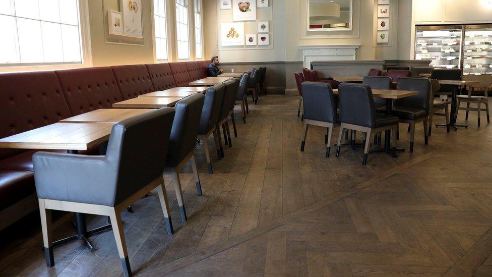 One man sits alone in an empty cafe