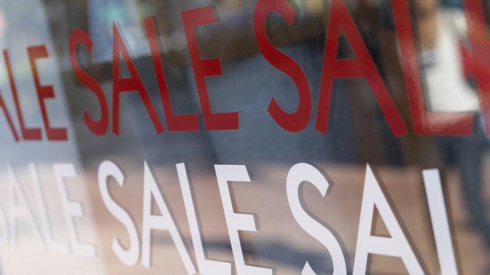 Sale signs in window