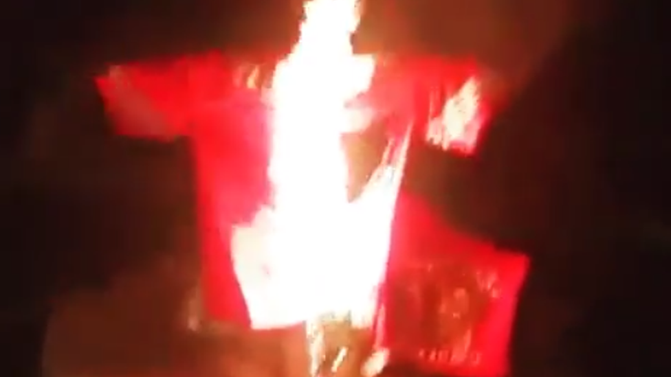 A jersey burns in protest against American Football player Colin Kaepernick