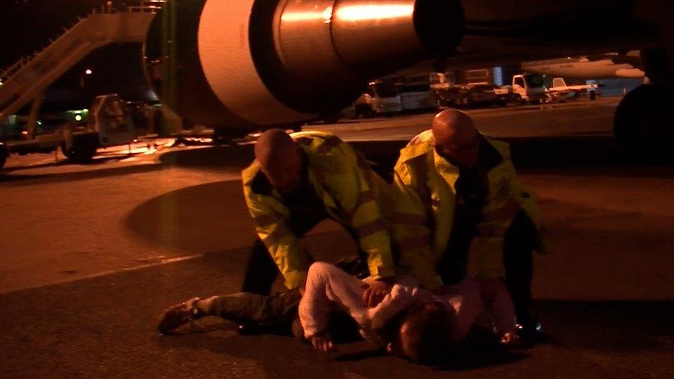 A protester being arrested on a runway