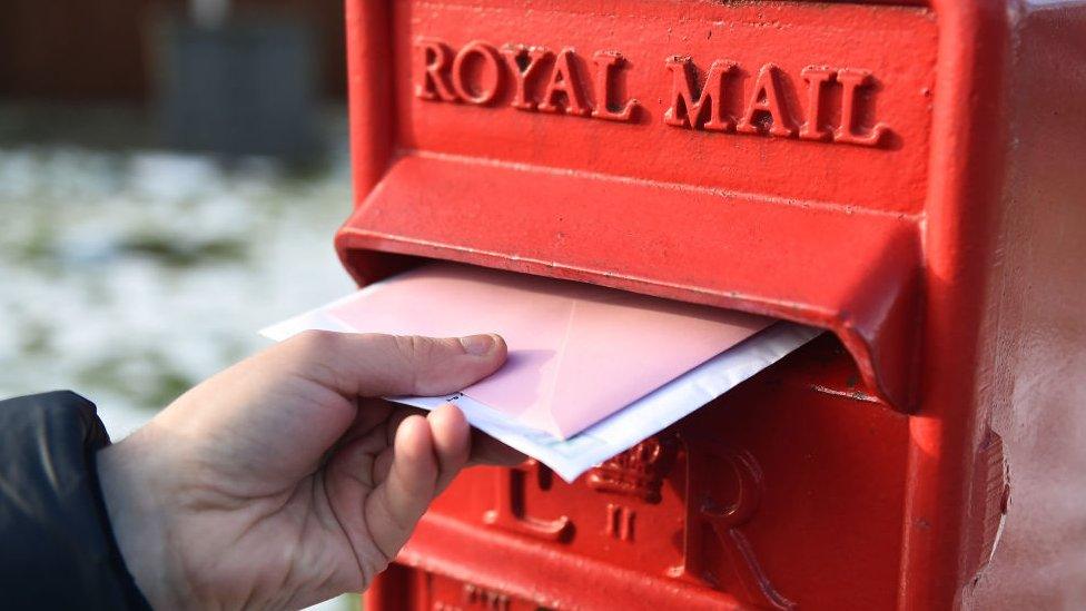 Letters are posted into a Royal Mail post box