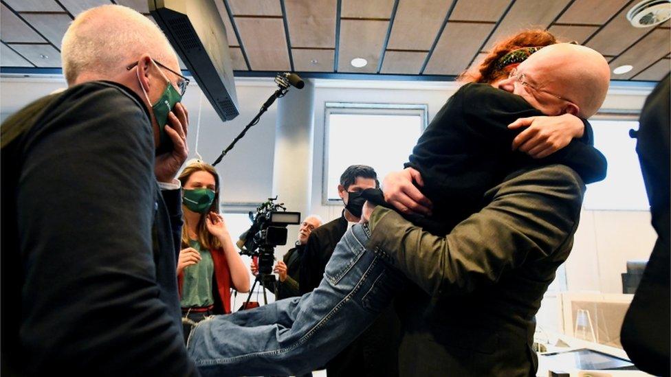 Environmental activists hug in court after a judge rules that Shell must cut its emissions