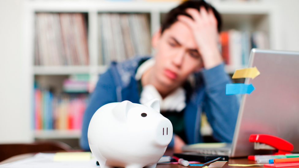 Student in front of piggy bank