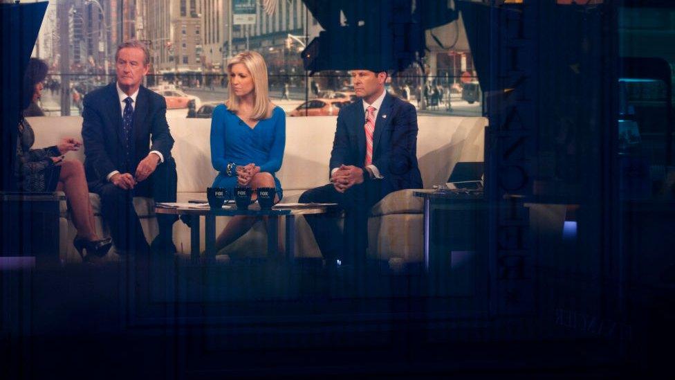 The hosts of Fox & Friends sit on set.